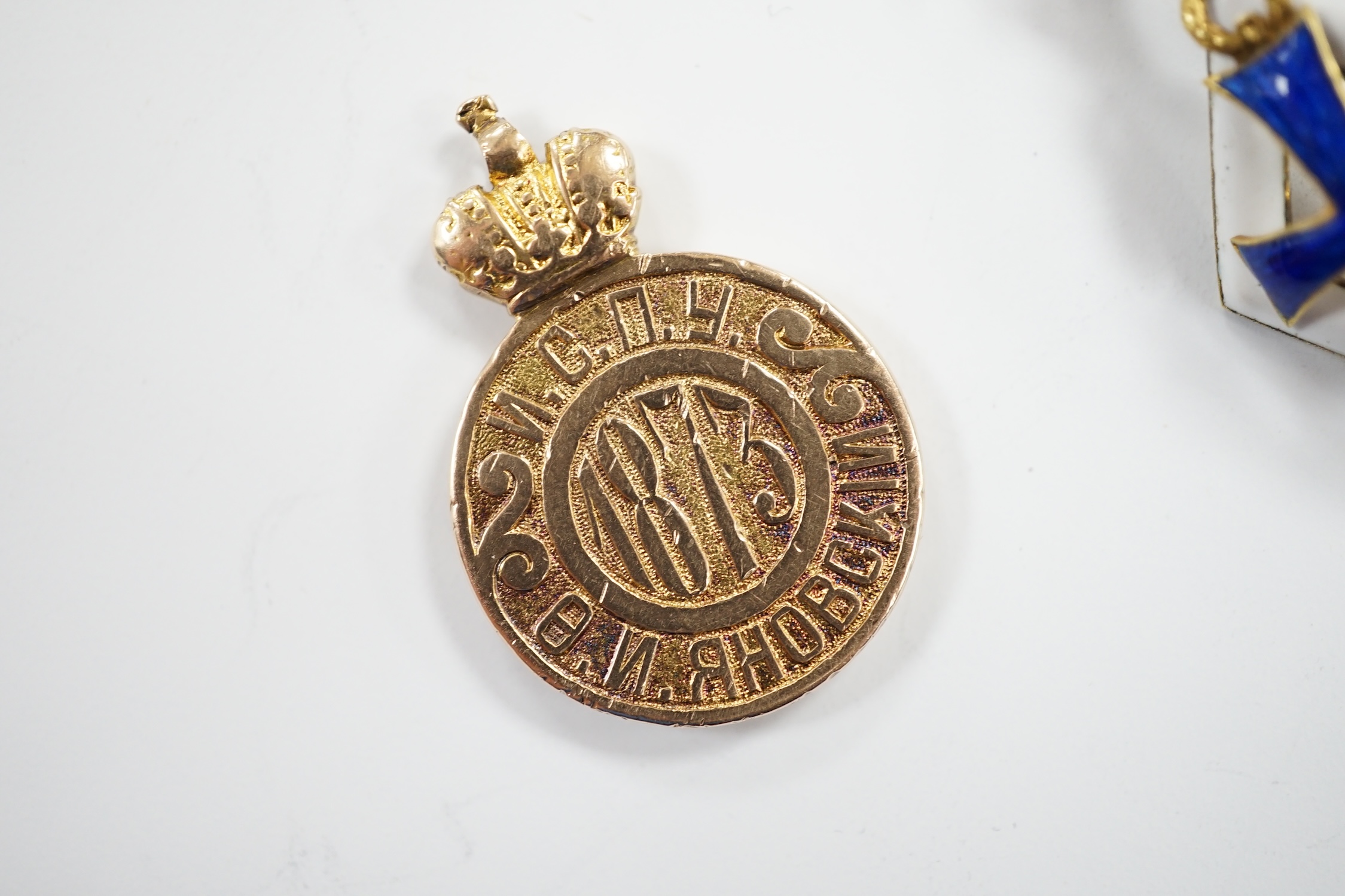 A Russian gilt white metal and enamel graduation from University of St Petersburg badge, 33mm and a yellow metal (tests as 14k) token for University Graduates, 5.1 grams.